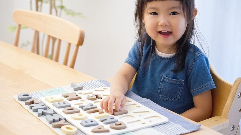 Child studying English with alphabet puzzles