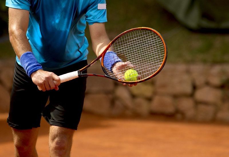A tennis player prepares to serve a tennis ball during a match.