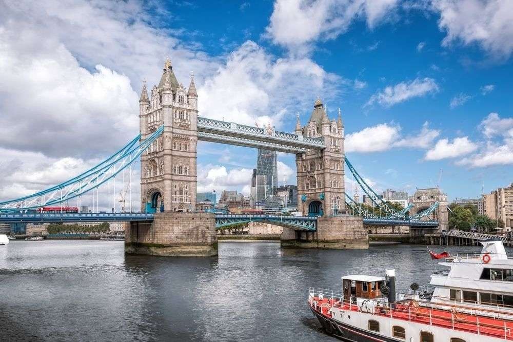 The iconic Tower Bridge with tourist boat in London, England, UK