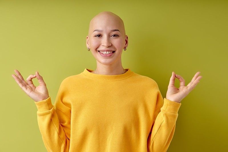 Happy and calm young bald woman