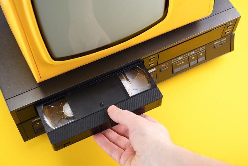 Person inserting VHS videocassette