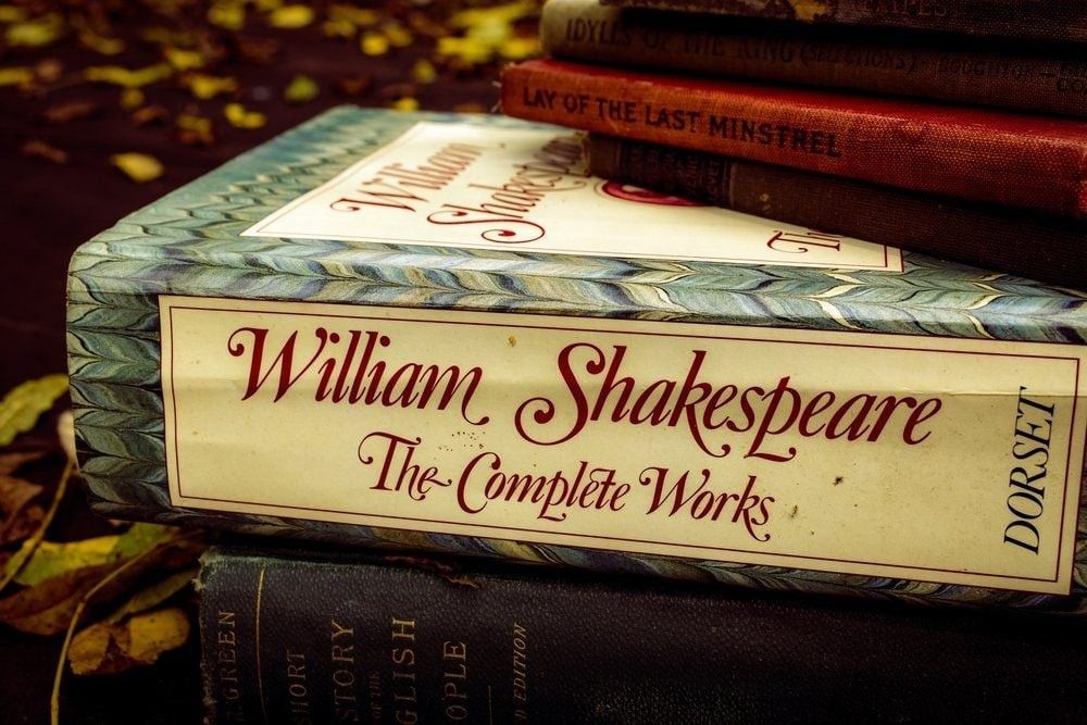 The Complete Works of William Shakespeare stacked in a pile of old vintage books for sale.