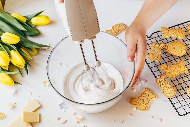 Person using mixer machine making cookie icing for decoration.