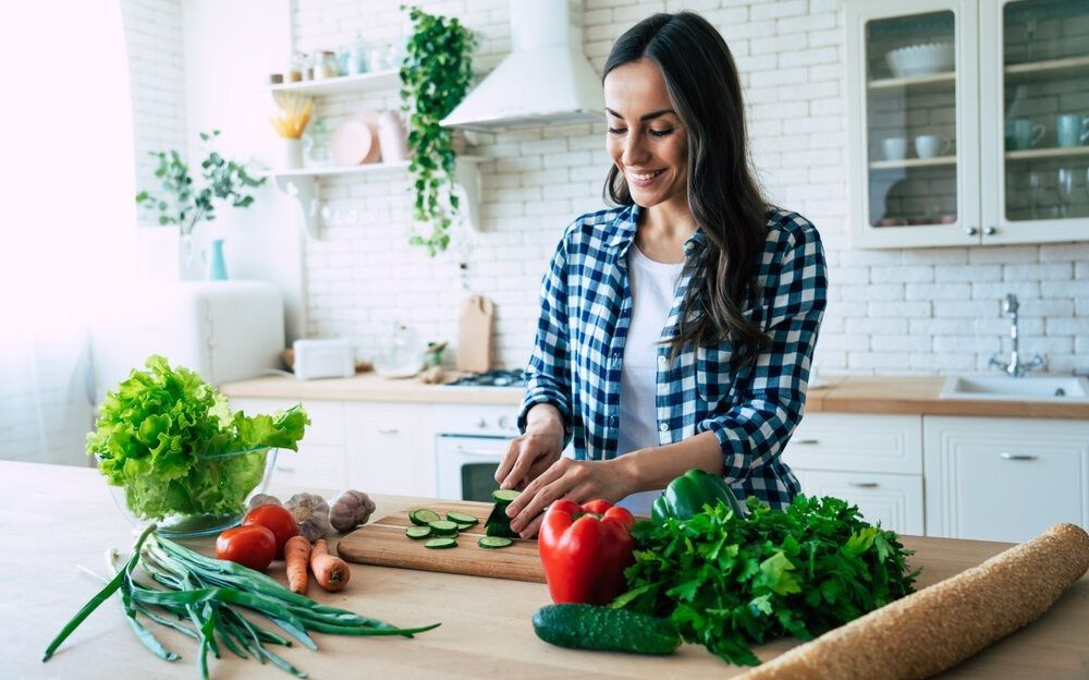 Woman cutting vegetables looking happy