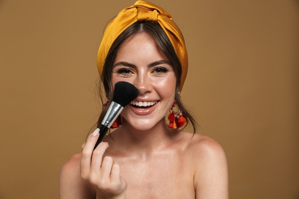 an attractive lovely young woman holding makeup brush